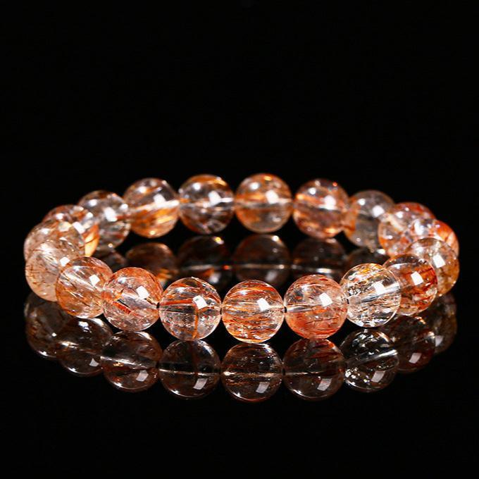 black gold super 7 bracelet round beaded crystal with golden rutile inclusions on black reflective surface