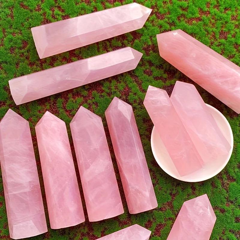 Multiple polished pink crystal points on green cloth including wholesale rose quartz tower display