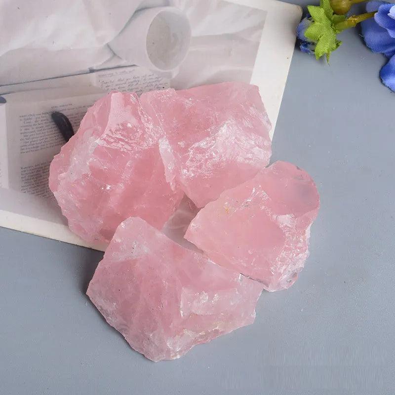 Pink raw rose quartz chunks from MLD Wholesale Crystals on gray surface wholesale rose quartz raw stones